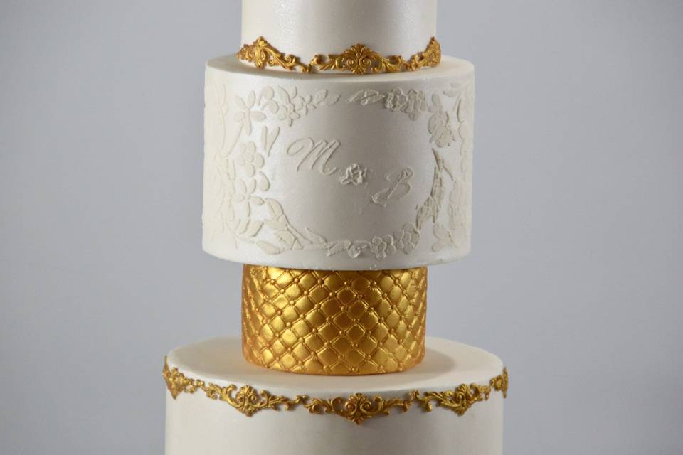 Four-tier gold and white cake