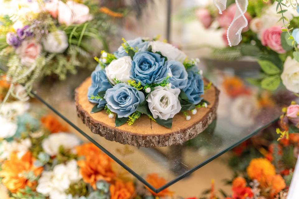 Blue and white rose arrangement on a wooden slice
