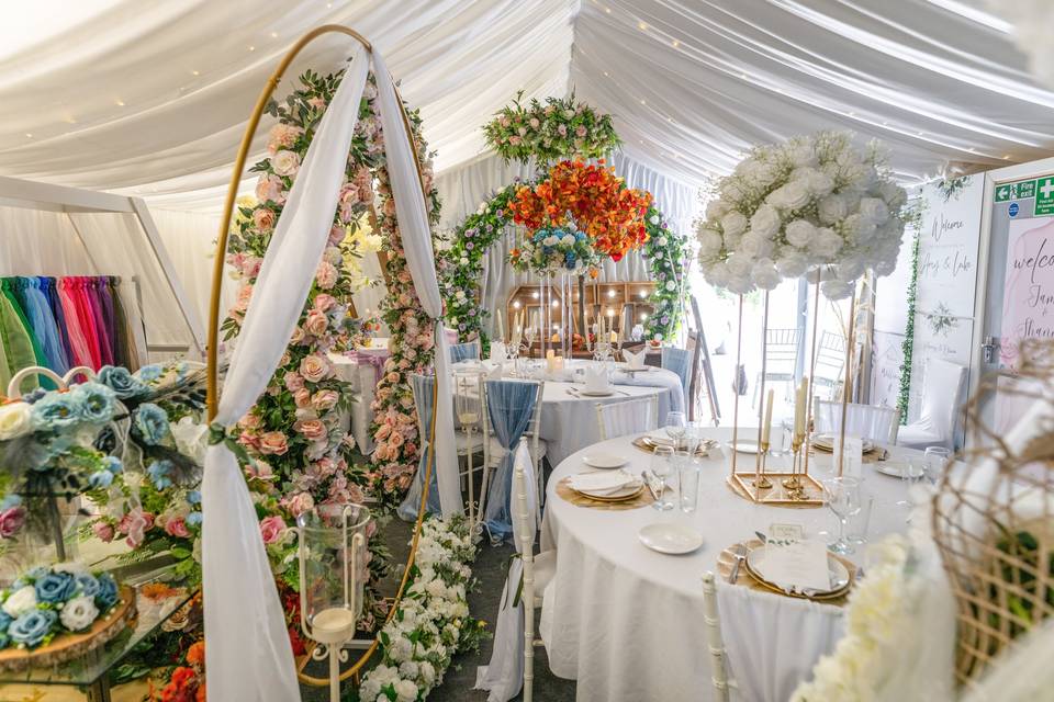 Event space with white floral arches and tables