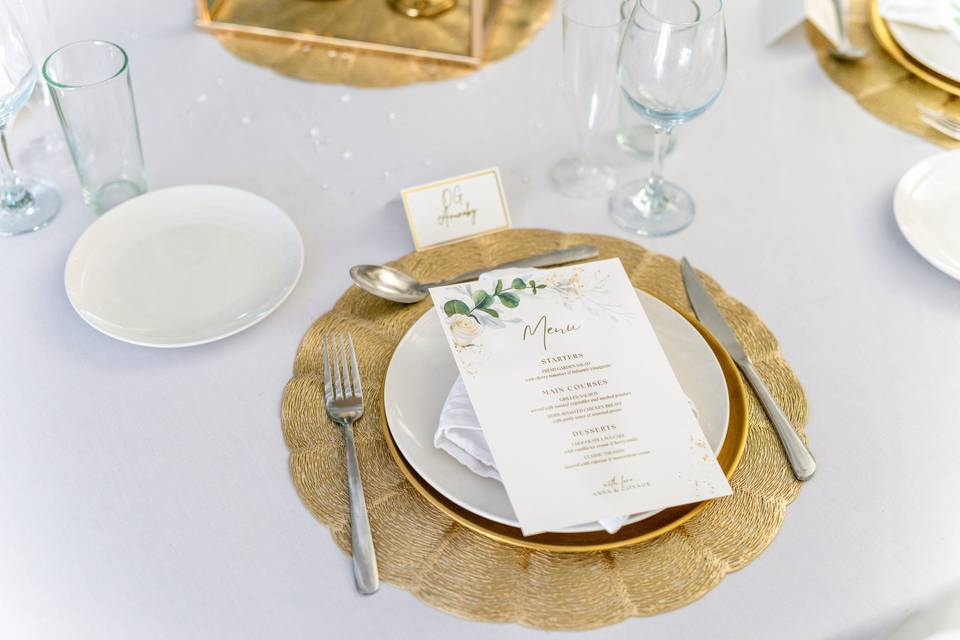 Gold-rimmed plate with menu and foliage