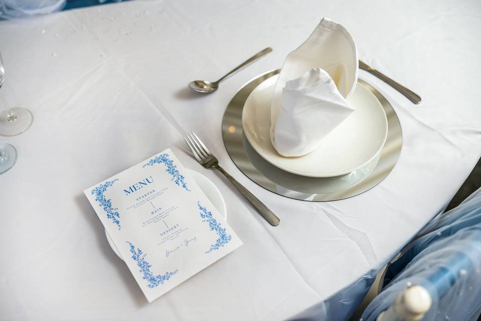 Place setting with light blue menu and napkin