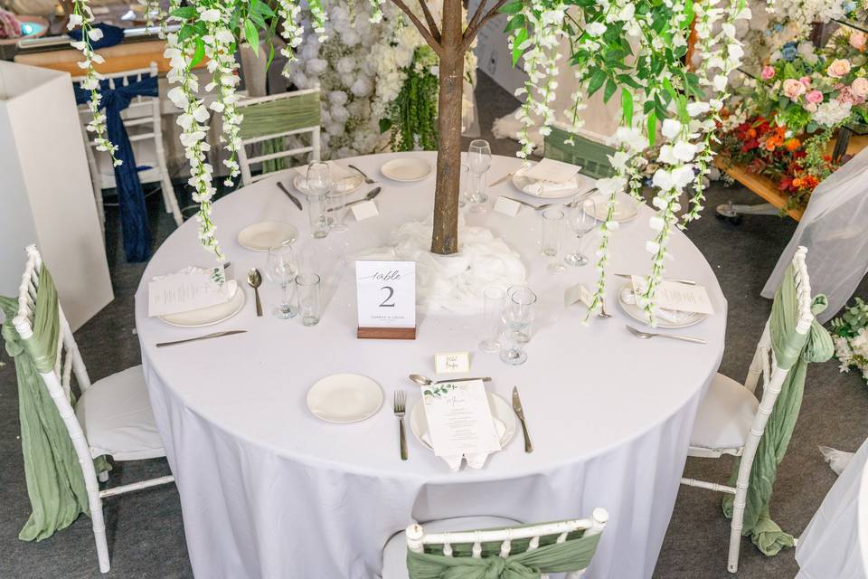 Round table with green napkins and white centerpiece