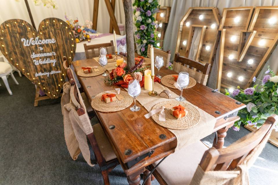 Wooden dining table with marquee lights background