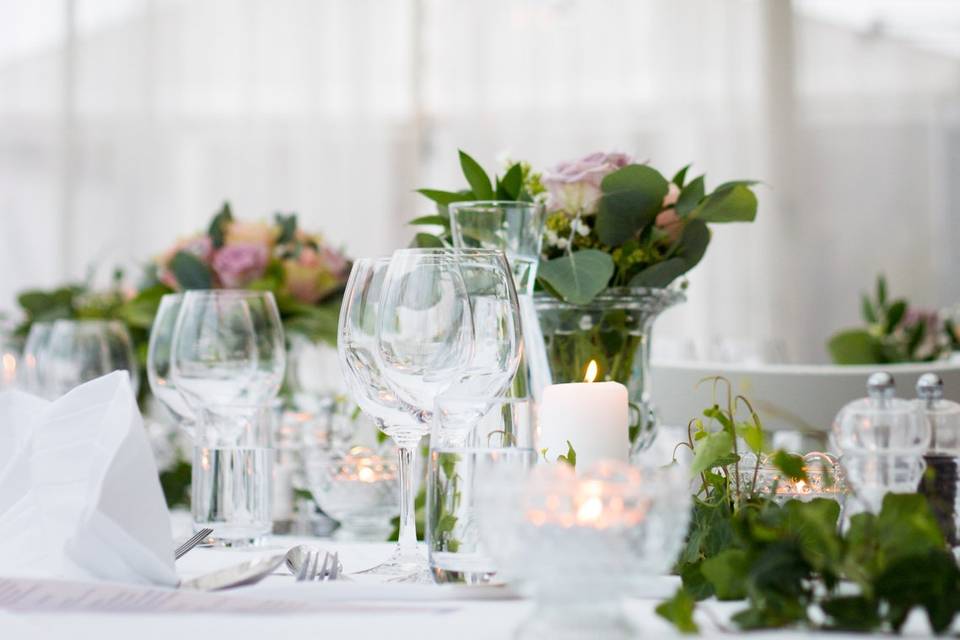 Glasses, candles, and floral arrangements