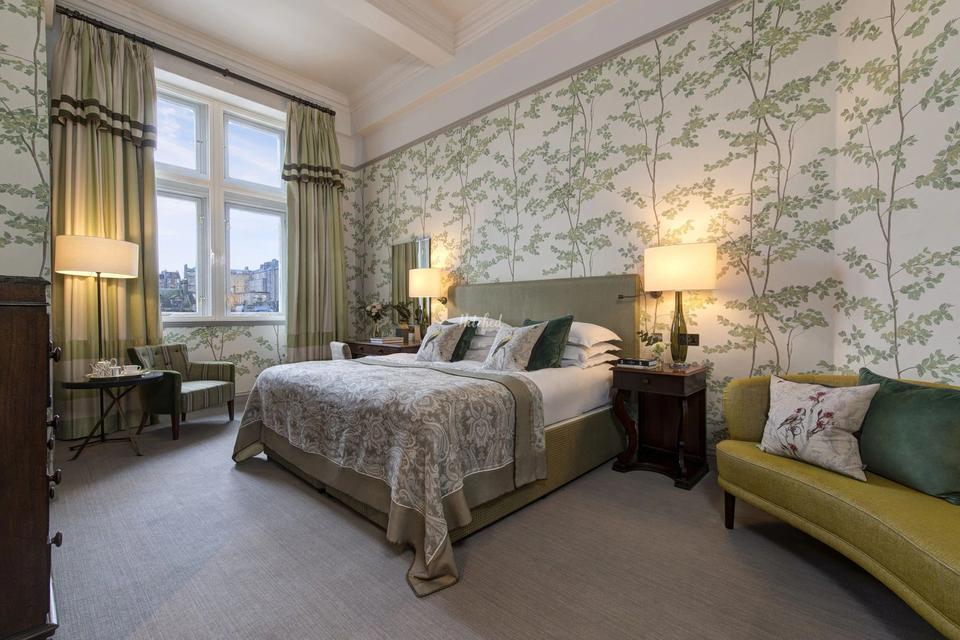 A beautifully decorated room at The Balmoral Hotel with floral wallpaper 