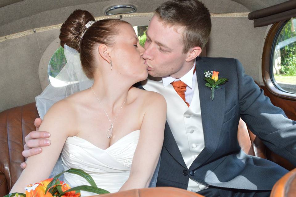 Newlyweds kiss in the car