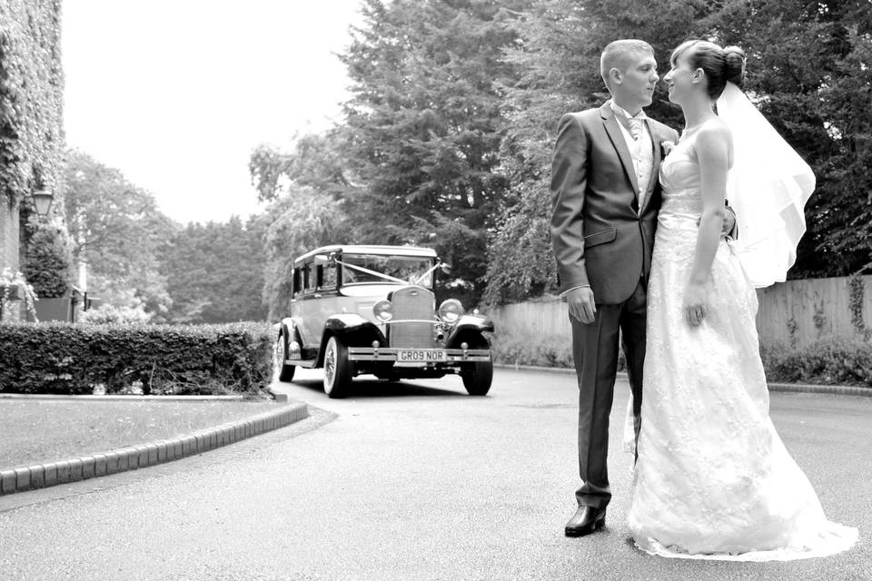 Standing in the road with a vintage car in the background