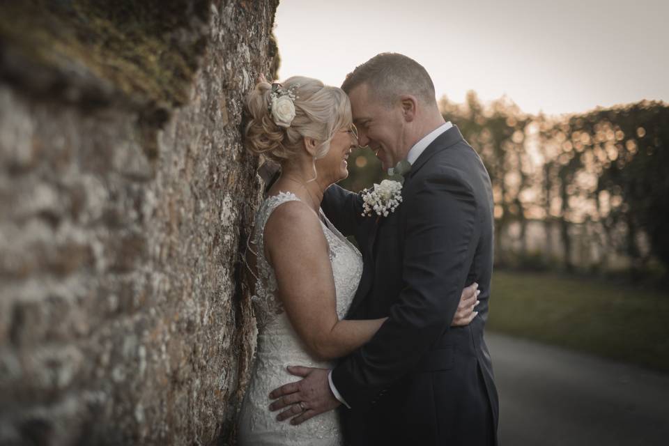 Couple embrace against wall