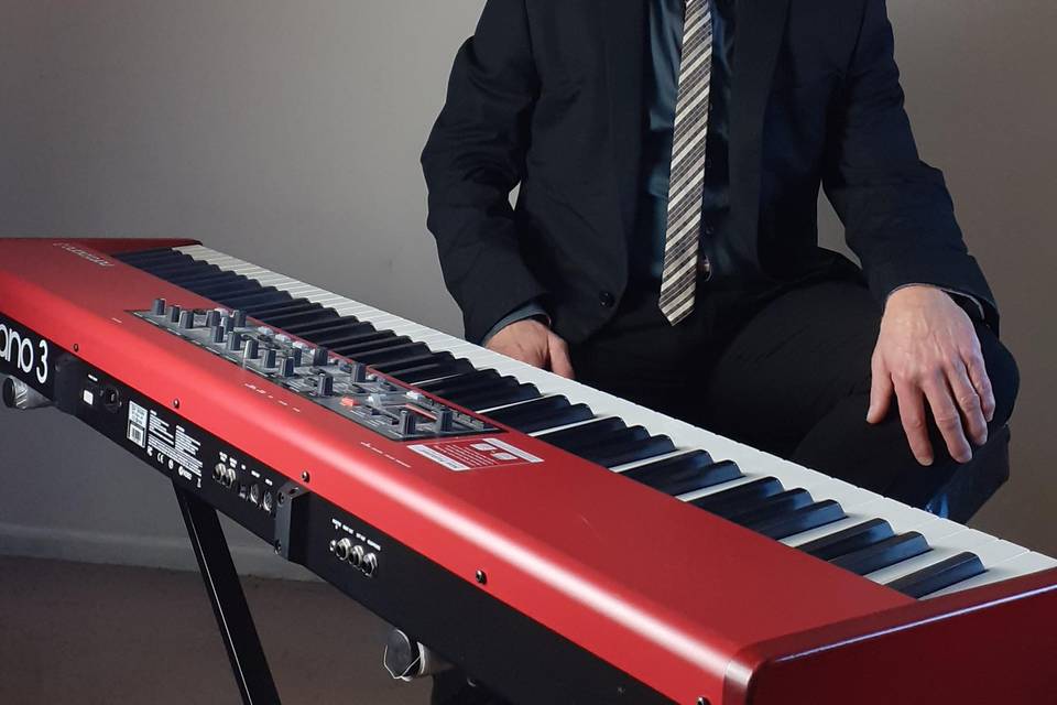 Seated by red piano