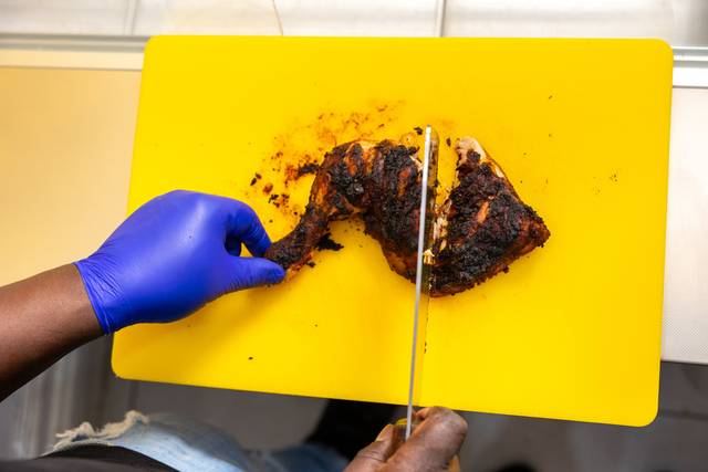 cutting grilled jerk chicken