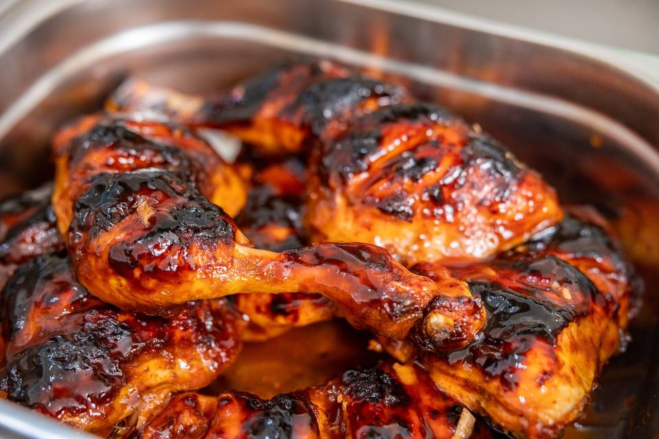 grilled bbq chicken pieces in tray