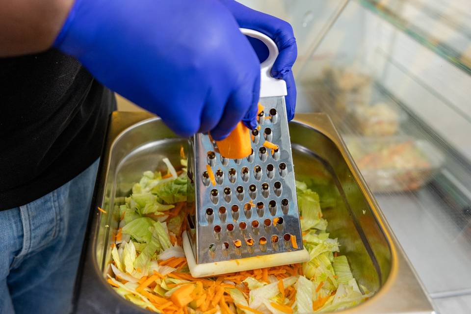 person grating carrots and cabbage