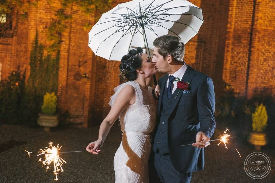 Bride & groom kissing with sparklers, Leez Priory