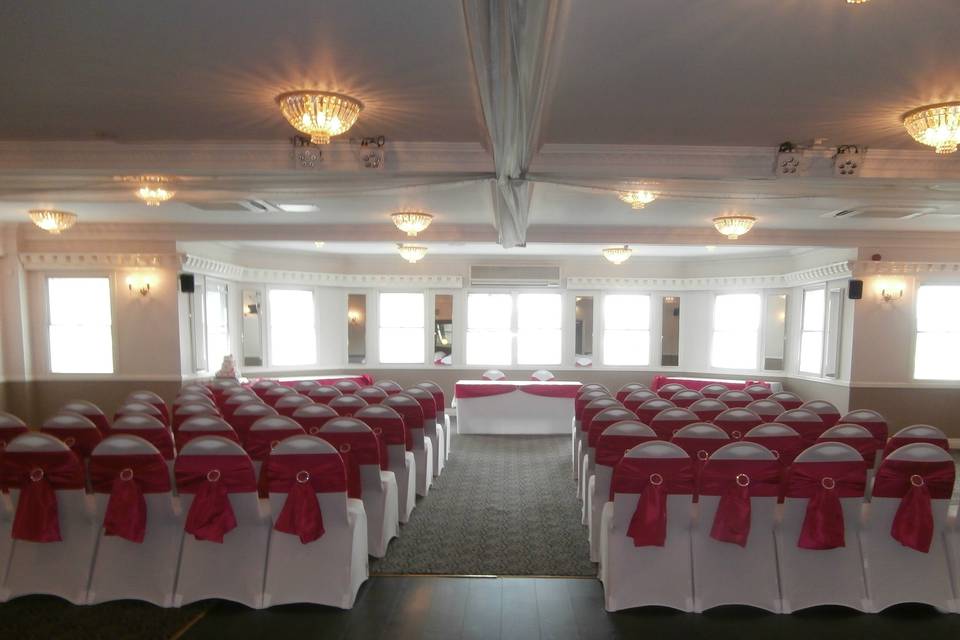 The Oysterfleet Hotel White Stretch Lycra Chair Covers with Fuchsia Tafetta Sashes Finished With Round Diamante Buckles