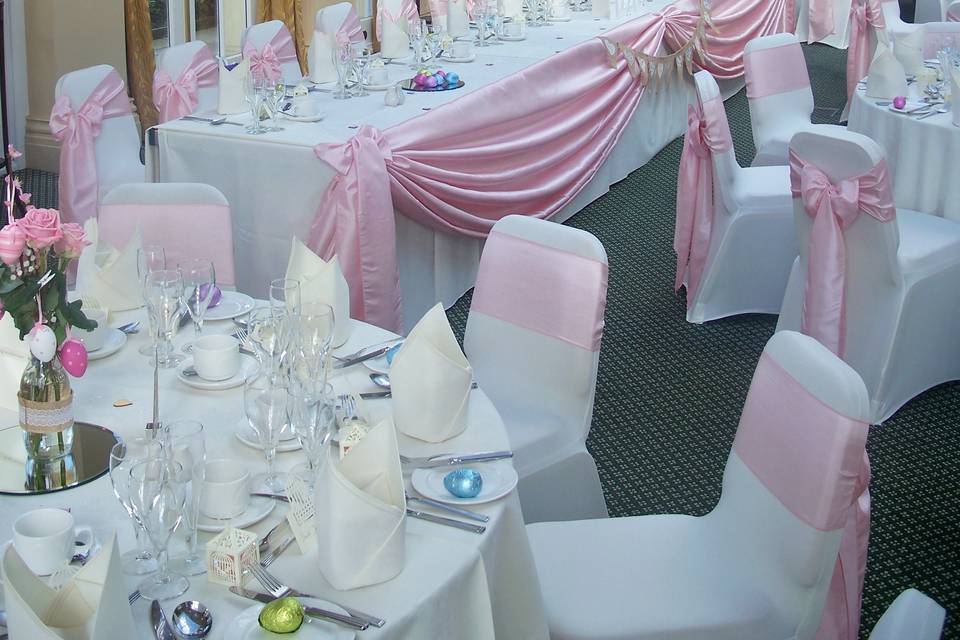 The Lawn Ivory Stretch Lycra Chair Covers with Baby Pink Tafetta Sashes with Baby Pink Tafetta Top Table Drape (Style 6)