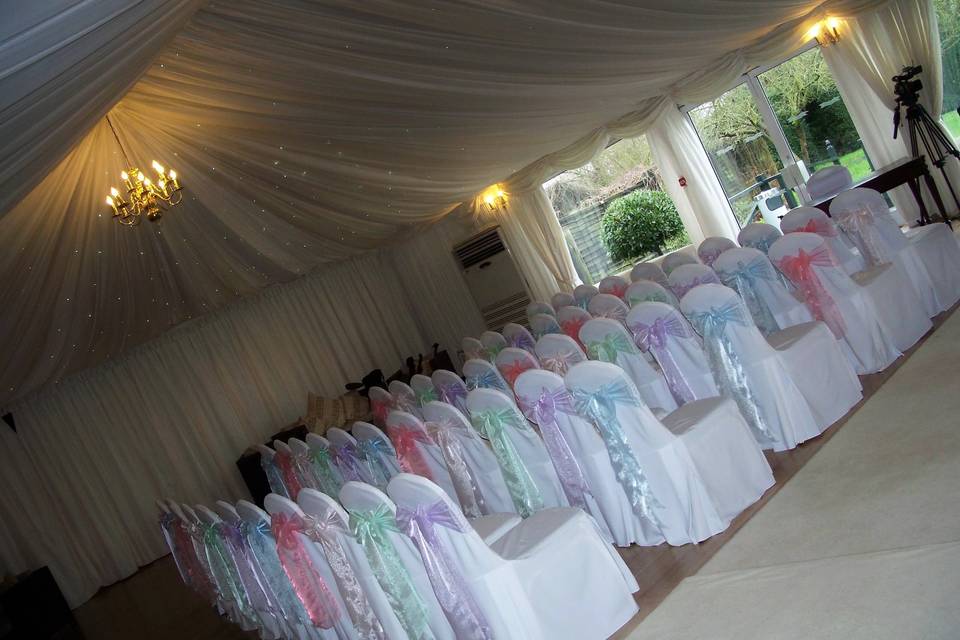 The Fennes Estate White Linen Chair Covers with Organza Sashes in 5 Mixed Pastel Shades (Baby Blue, Coral, Lilac, Mint Green & Pale Pink)