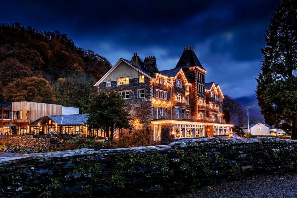 evening shot of a beautifully lit Lodore Falls Spa Hotel at dusk in winter with light snow everywhere