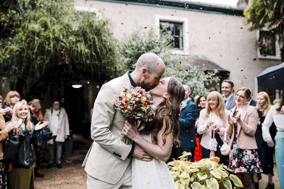 Newlyweds kiss outside