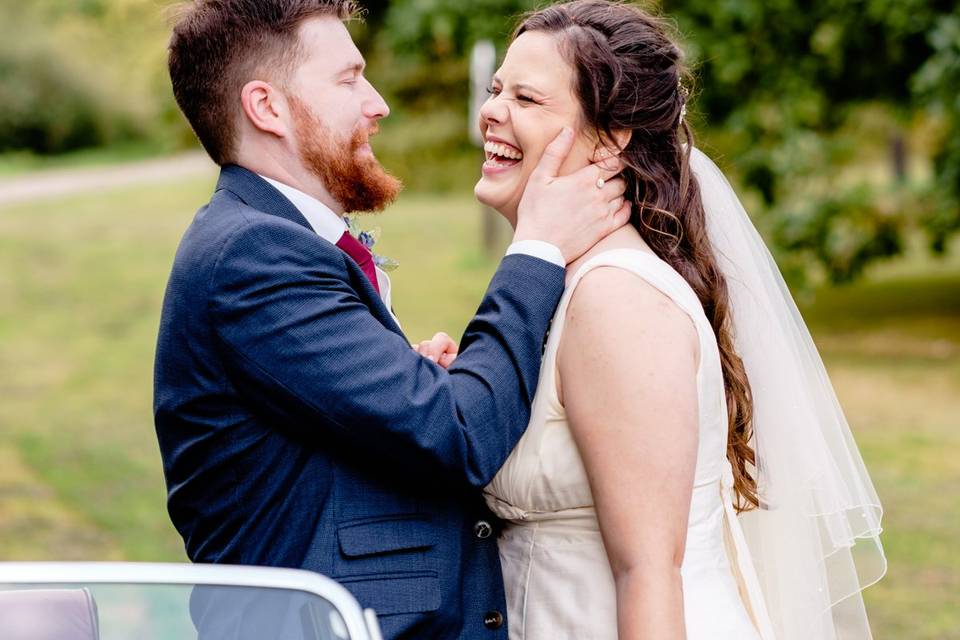 Bride and groom by classic car