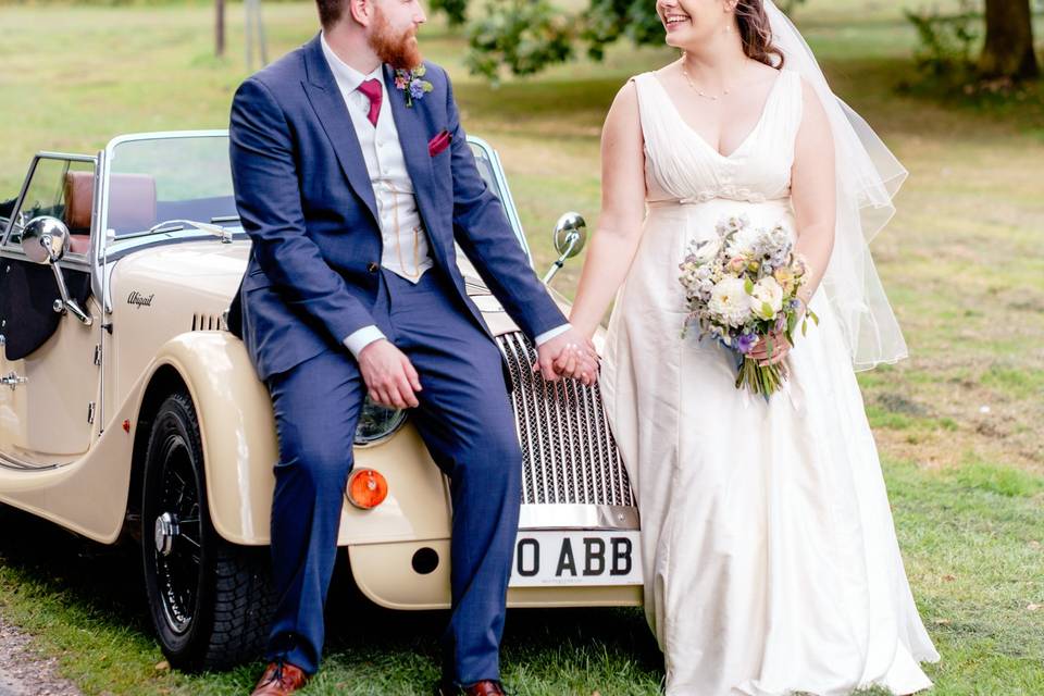 Bride and groom by classic car