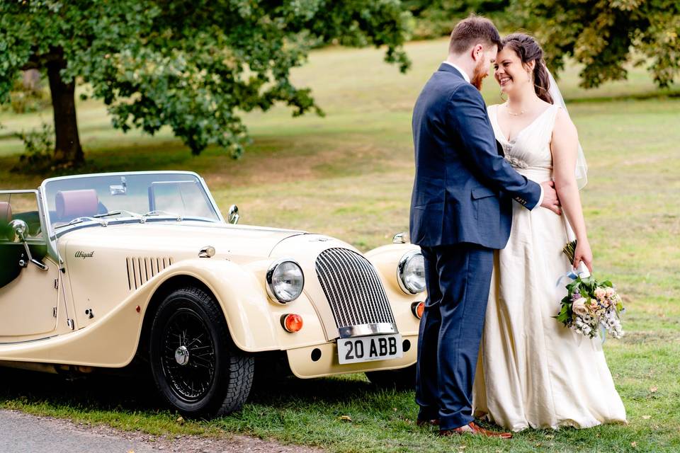 Bride and groom by classic car