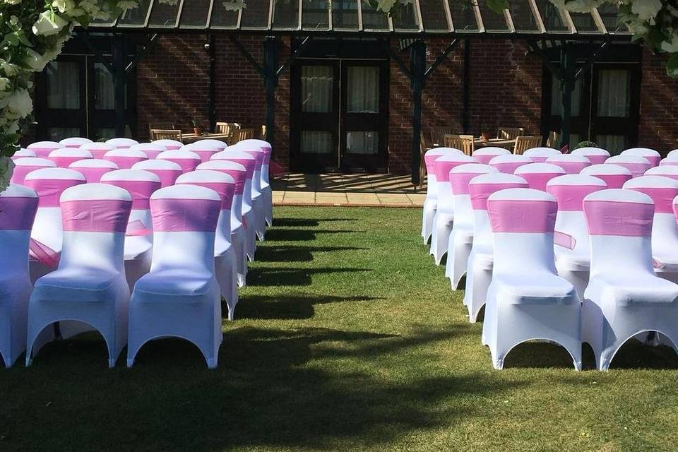 White chair covers and pink sashes