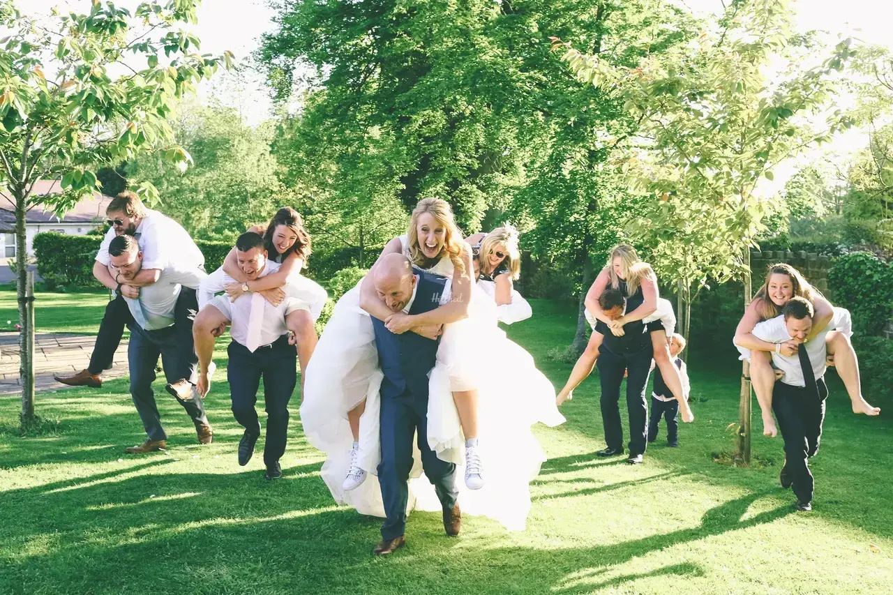 a bride and groom and members of their wedding party all on eachother's backs having a race at Ribby Hall Village 
