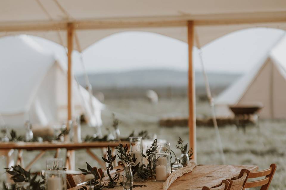 Rustic tables and chairs under marquee