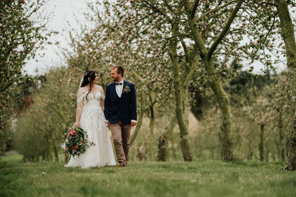 Bride and groom in orchard